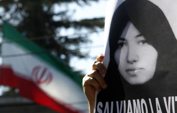 Sakineh Mohammadi-Ashtiani nuotrauka Irano vėliavos fone