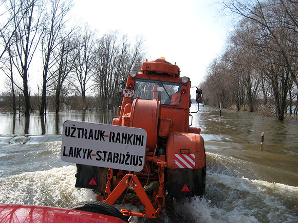 Per apsemtą kelio ruožą keliamas automobilis