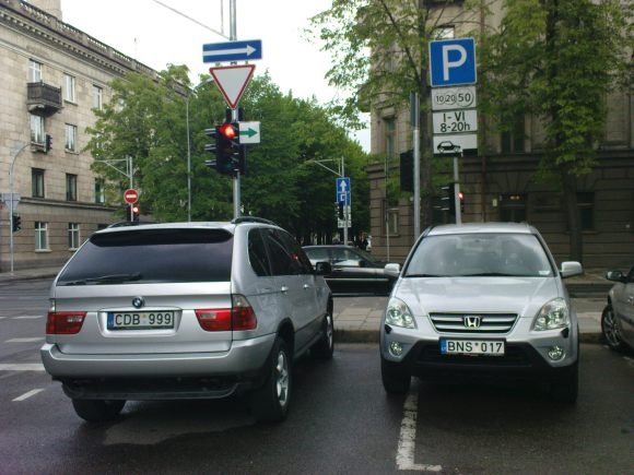 Šis BMW X5 visureigis tamsintais langais ir išskirtiniu numeriu neturėjo nei bilietėlio, nei lipduko, skirto mokėti už paslaugą trumposiomis žinutėmis, o dešiniau stovinčiame „Honda“ automobilyje bilieto galiojimo laikas buvo pasibaigęs.