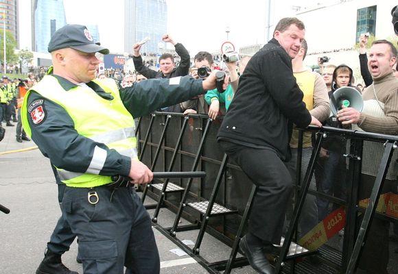 Seimo narys Kazys Uoka veržiasi pro policininkus.