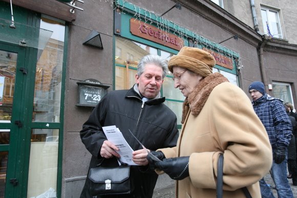 Vidas Puskepalis prie prekybos centro dalina skrajutes ragindamas paremti kasininkus maisto produktais.