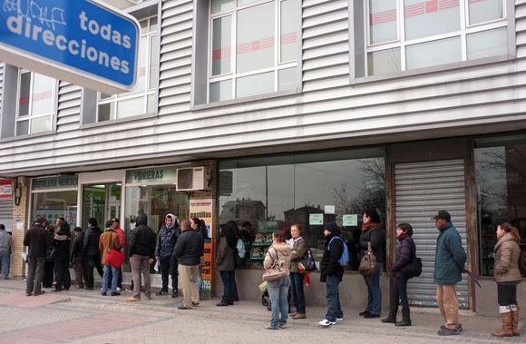 Žmonės laukia prie įdarbinimo biurio Madrido rajone.