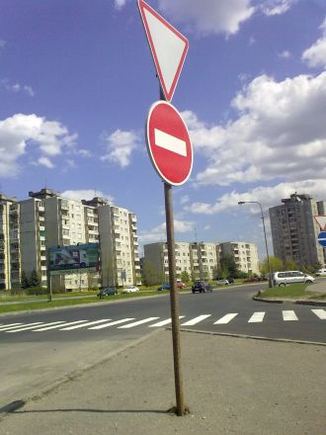 Prieštaraujantys vienas kitam kelio ženklai.